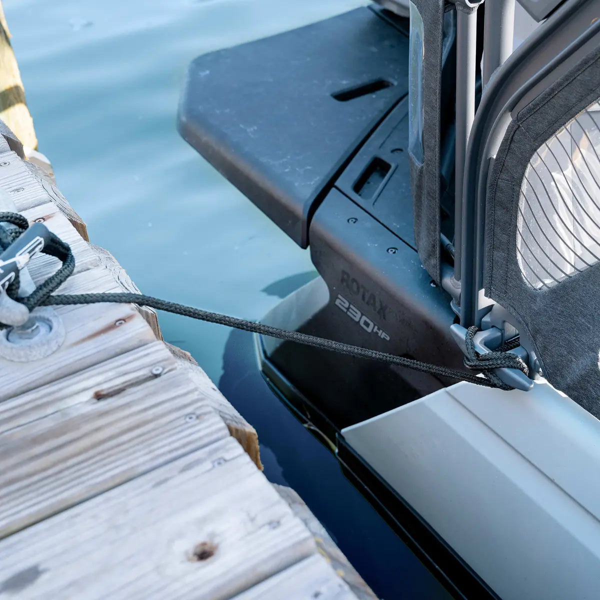 Sea-Doo Switch Speed Tie docking accessory; black rope secures BRP Sea-Doo boat to wooden dock.