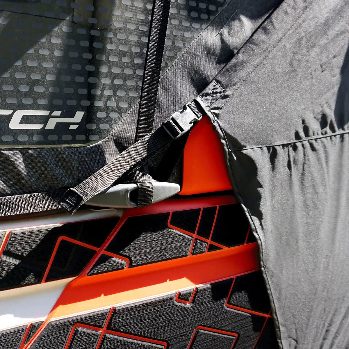 Switch cover for Sea-Doo Switch front trailering, black fabric with straps and buckle, orange watercraft accents visible.