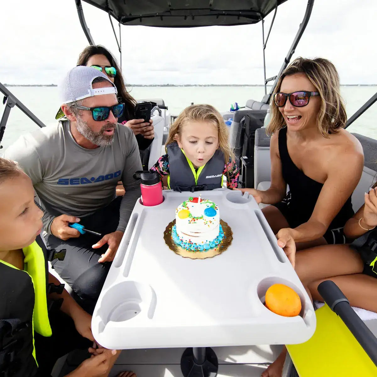 Sea-Doo Switch Adjustable Table, white plastic watercraft table with cup holders aboard a Sea-Doo boat