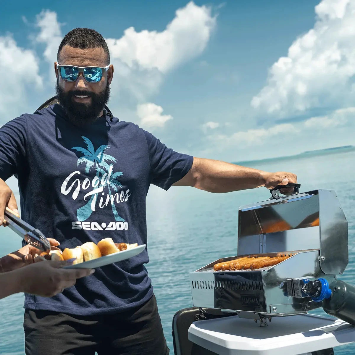 Sea-Doo Switch BBQ Table with LinQ Lite, stainless steel grill on a Sea-Doo watercraft, man grilling sausages