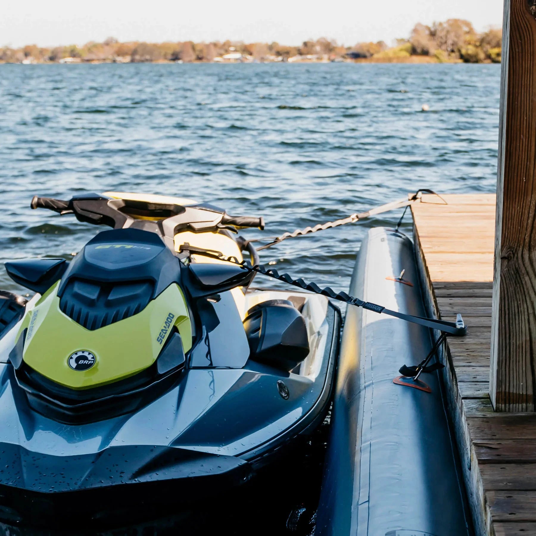 Mission PWC Tethers dock lines in black securing a blue and lime Sea-Doo jet ski at a wooden dock.