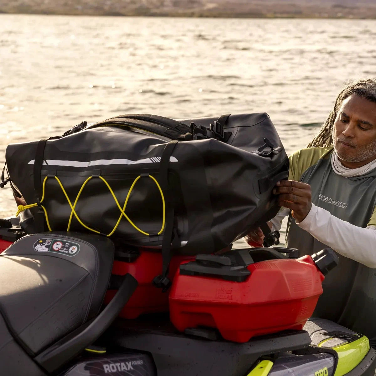 Sea-Doo LinQ Explorer Bag on a jet ski, black storage bag with yellow bungee cords.