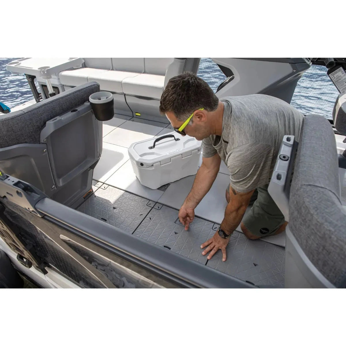 Sea-Doo Switch LinQ Cargo Tile on gray boat deck; man kneels beside a white cooler.