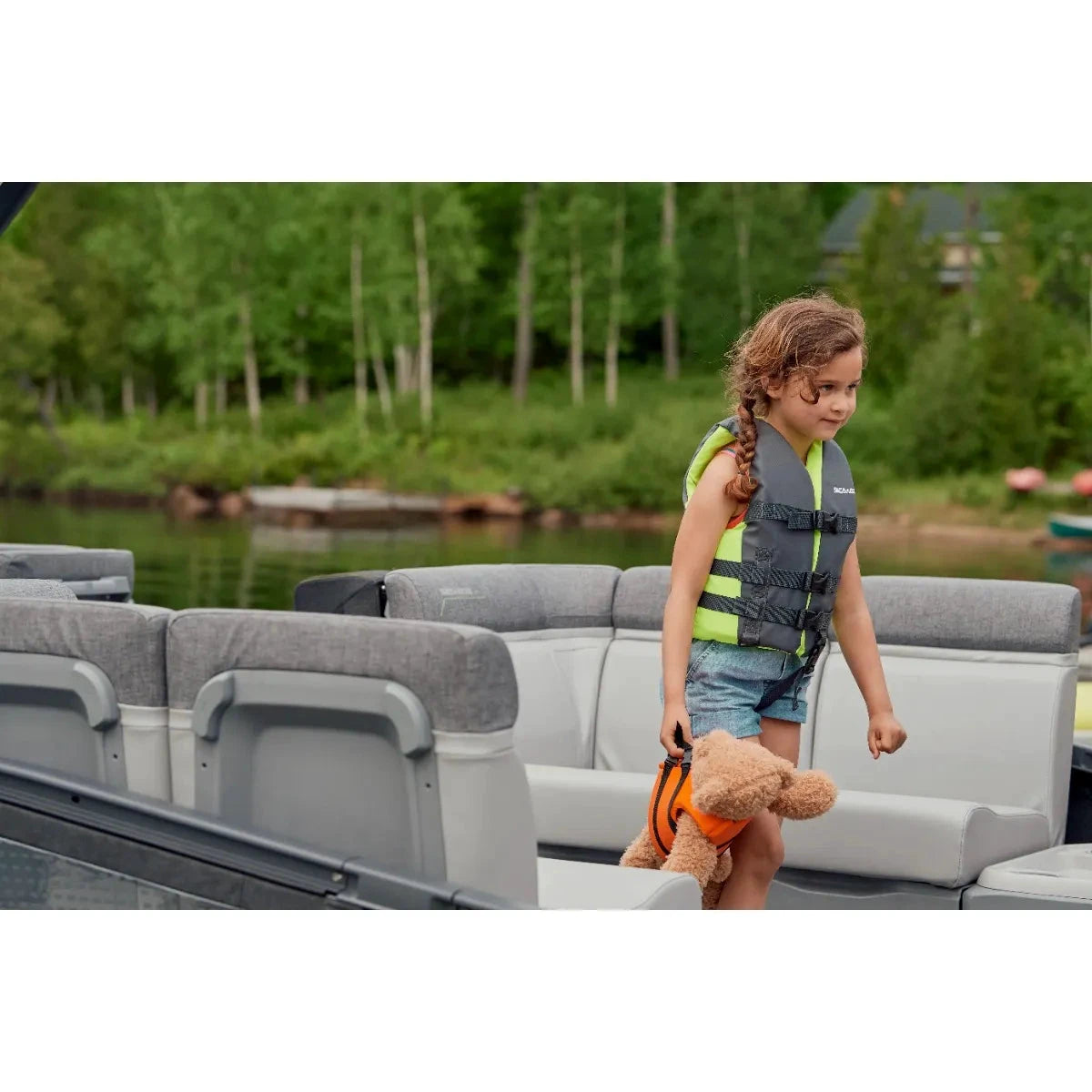 Sea-Doo Sandsea Kids' PFD life jacket, lime green/gray; two shown on child and stuffed dog on a boat.