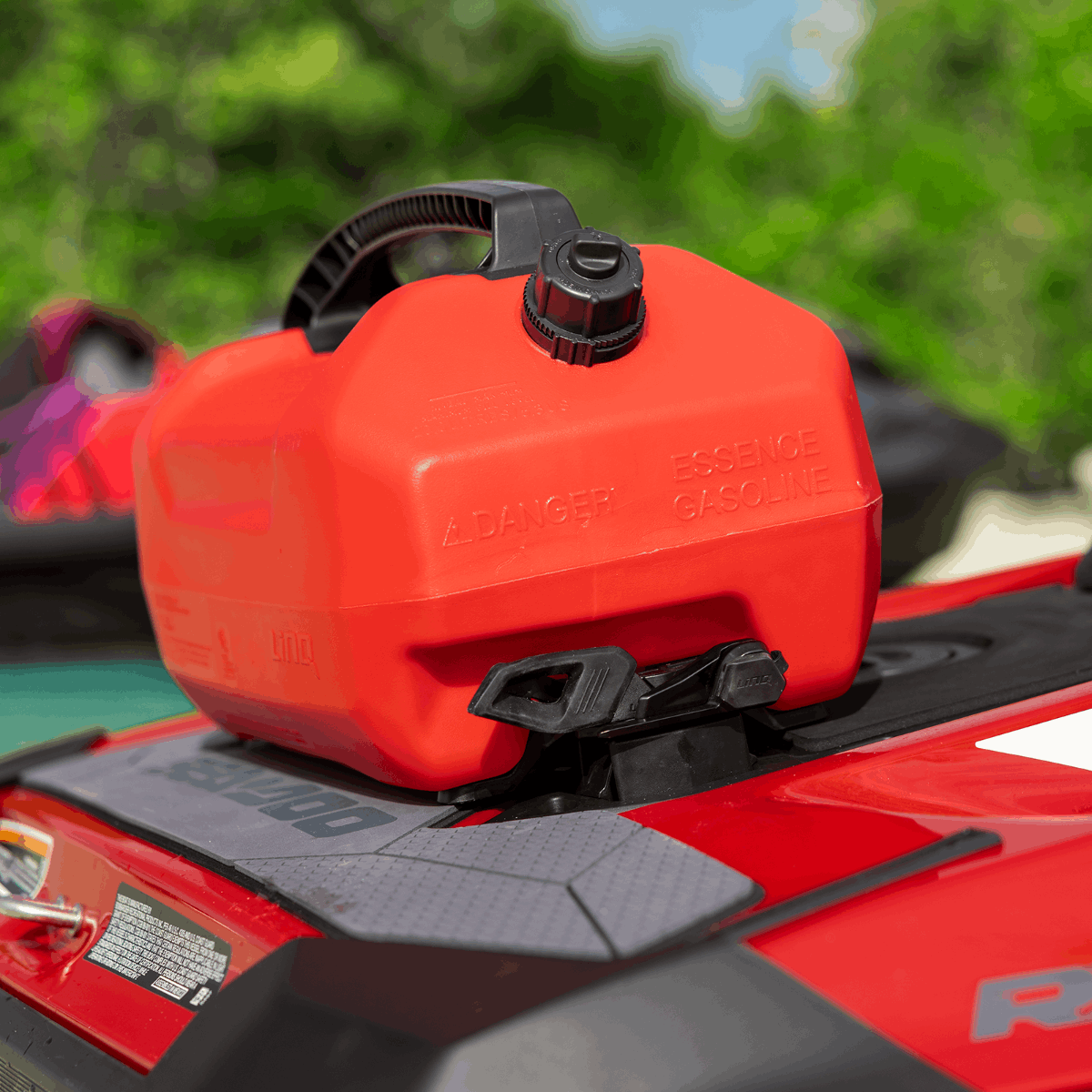 Sea-Doo LinQ 5-Gallon Fuel Caddy, red plastic tank with black cap, mounted on a Sea-Doo watercraft with mounting strap.