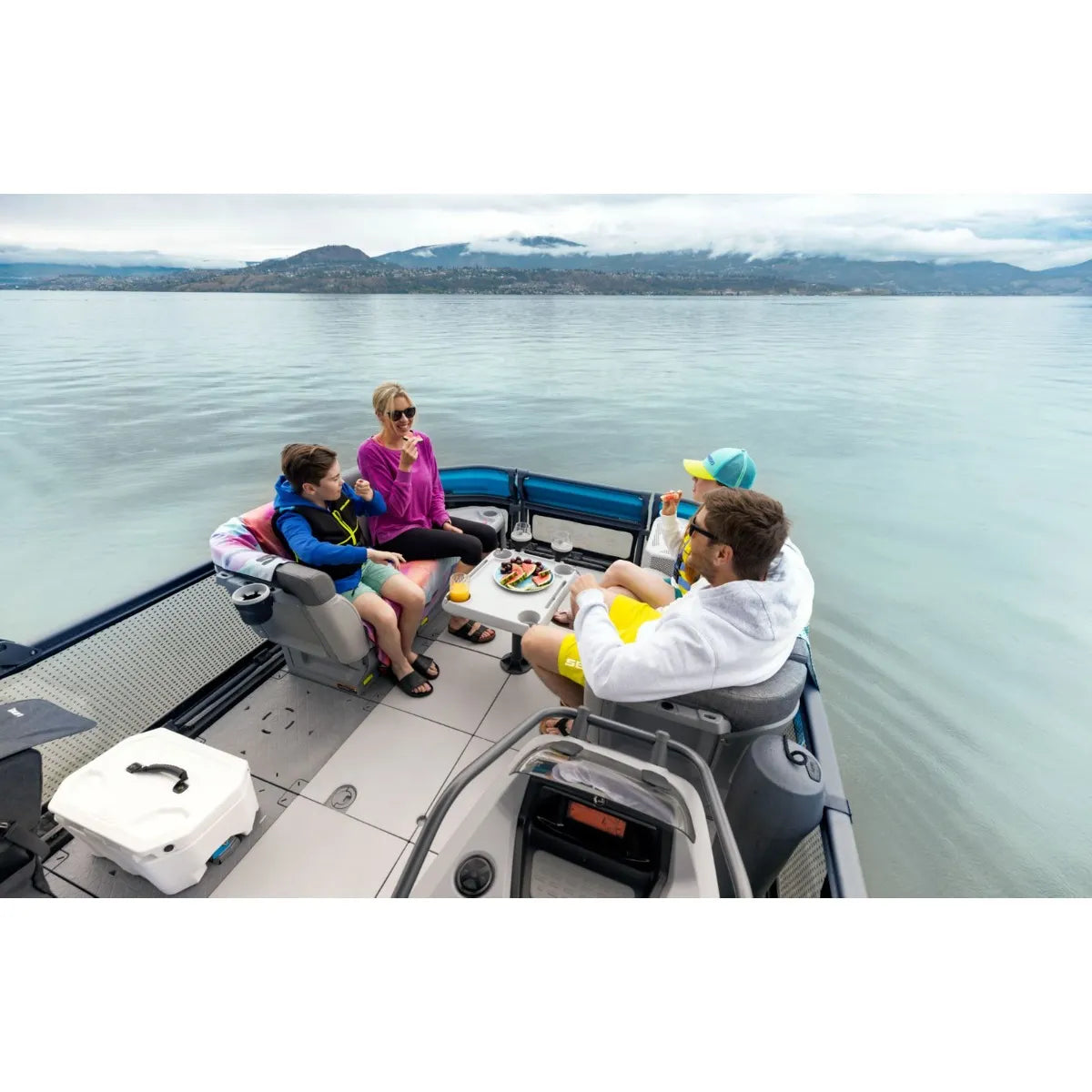 Sea-Doo Switch Adjustable Table on a blue watercraft with four people dining around a white table